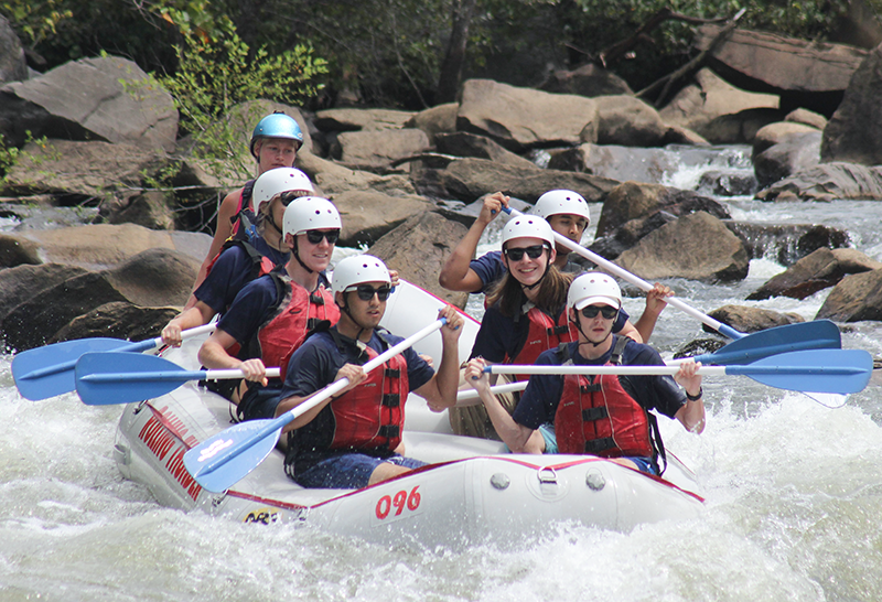 A group of GT young women and men river rafting..
