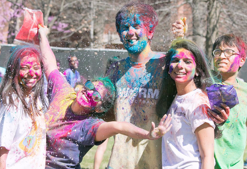 Three GT young women and two young men splashed in paint. 