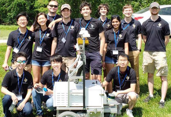 A group of GT students behind a wheeled contraption they built.
