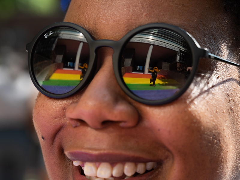 Buzz is reflected in Christen Steele’s glasses as she admires the Progress Pride Staircase at its grand opening in 2021. Photo by Allison Carter